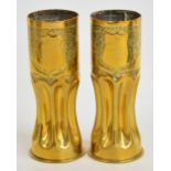Two brass artillery shell trench art vases decorated with leaves and a shield bearing the