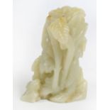 An early 19th century Chinese pale green jade carving depicting Guanyin beneath a palm tree, the