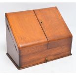 An Edwardian oak stationery box with twin doors enclosing perpetual calendar,