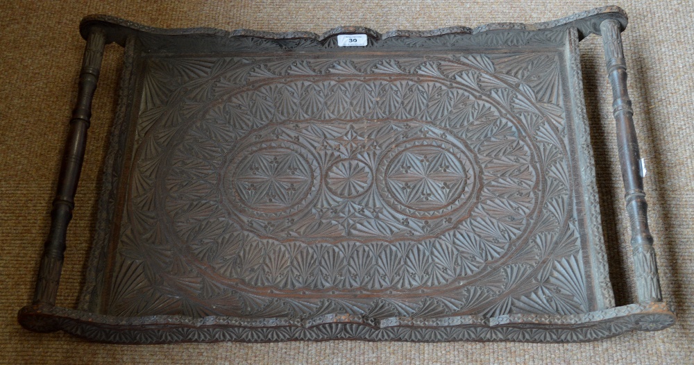 A profusely carved decorative Indian rectangular tea tray with scrolling handles, width 71cm.