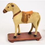 A toy pony standing four square on rectangular wooden base.