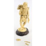 A Japanese Meiji period ivory okimono of a woodcutter with a roll of logs on his back, and