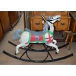 A vintage carousel horse, now mounted as a rocking horse on a contemporary wrought iron frame.