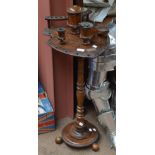 An early 20th century oak smoker's stand with shield shaped platform set with four trinket pots and