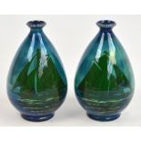 A pair of ceramic ovoid vases with a decoration of green yachts on a sea and sky blue ground, with