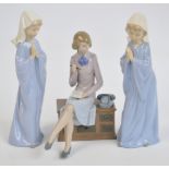 Three Nao figures; lady seated on a telephone table and two young girls as nuns. CONDITION REPORT: