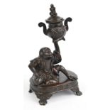 A Japanese Meiji period bronze twin handled censer and cover supported by a seated robed monkey on