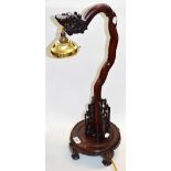 A decorative carved Chinese table lamp decorated with a stylised dragon, height 65cm.