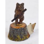 A late Victorian novelty tape measure modelled as a cold painted bear on a stump, height 4cm.