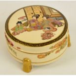 A Japanese Meiji period Satsuma circular box and cover decorated with seated figures to the lid