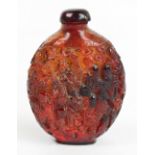 An early 20th century Chinese carved amber ovoid snuff bottle, decorated throughout with boys and