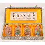 A cased set of 20th century Chinese glass interior decorated snuff bottles depicting floral sprays,