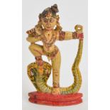 An Indian polychrome painted carved wooden gilt heightened figure raised on lozenge shaped plinth