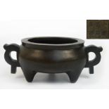 A 17th/18th century Chinese bronze tripod censer with two finely cast handles in the form of