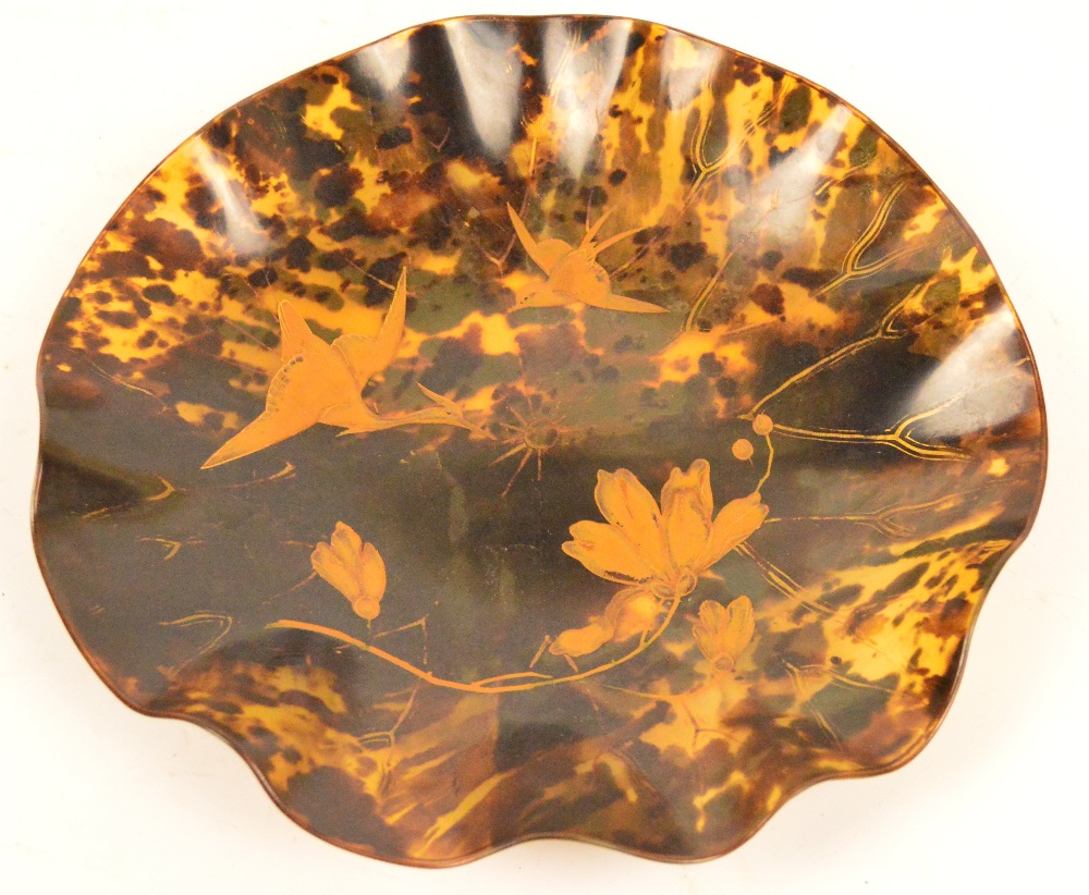 An early 20th century Japanese moulded tortoiseshell circular dish with lacquered decoration
