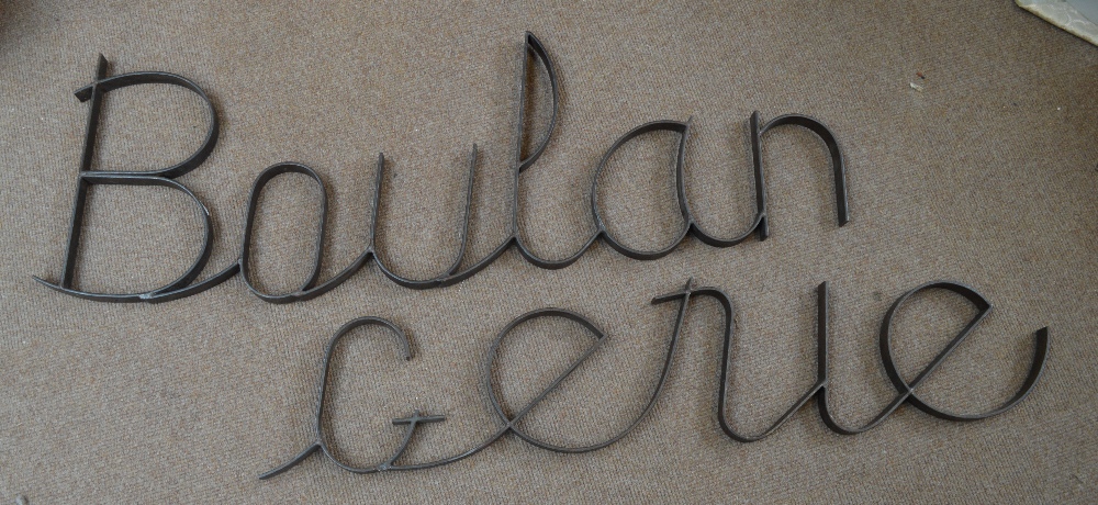 Three sections of wrought iron lettering spelling "Boulangerie".