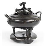 An 18th/19th century Chinese bronze tripod censer with pierced cover and blossoming prunus branch