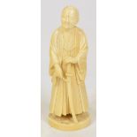 A late 19th century Chinese carved ivory figure depicting a robed man holding a sword,