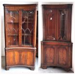 Two corner units with upper glazed doors and Greek key decoration to the top,