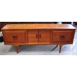 A retro teak sideboard with four sliding cupboard doors raised on tapering square sectioned