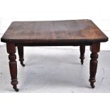 A late 19th early 20th century mahogany dining table on ring turned and fluted legs,