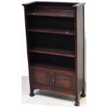 An Arts and Crafts style bookcase with two doors to base,