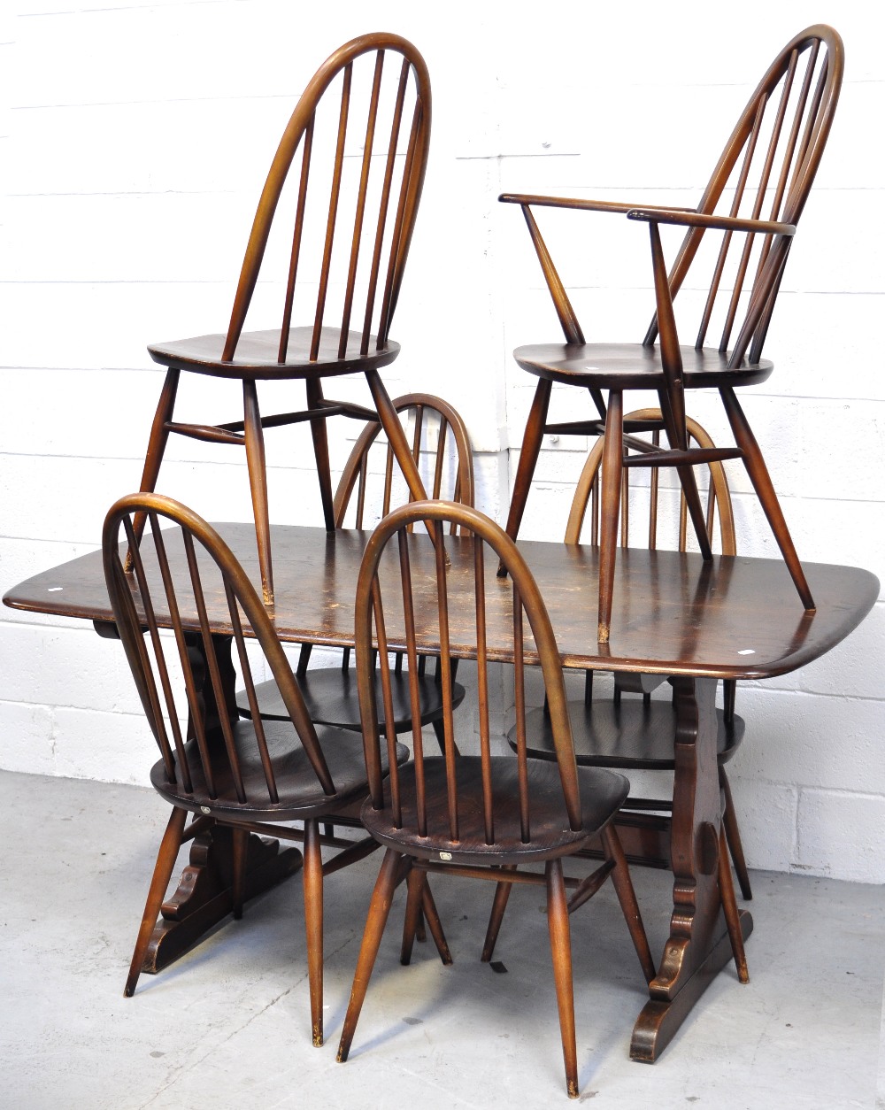 An Ercol dining table and six matching chairs (5+1), length 153cm.