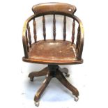 An early 20th century Captains style swivel chair, ring turned supports to leather seat on castors.