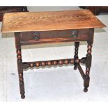 An Edwardian two drawer oak table on turned legs.