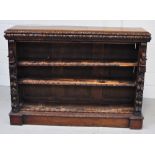 A Victorian oak two shelf bookcase with carved figures to either side and a heavily carved frieze