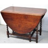 An early 20th century oak drop leaf table on barley twist supports,