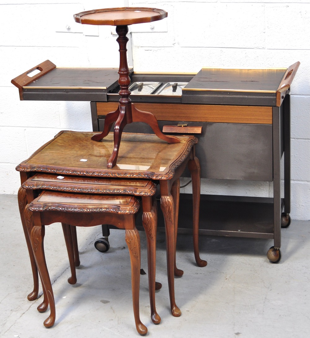 A small round side table a retro hostess trolley on ball feet and a nest of three walnut tables