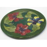 A Moorcroft Hibiscus on dark green/blue ground platter,