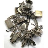 A silver charm bracelet set with approximately twenty charms, approx weight 2.2ozt.