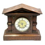 An early 20th century oak case mantel clock, enamel and gilded dial set with Roman numerals,