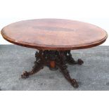 A Victorian oval walnut dining table of small proportions on heavily carved base decorated with