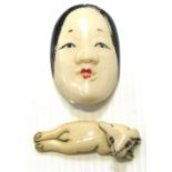 Two ivory netsuke, one as a Japanese lady's face the other as a small dog, both signed to the base.