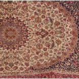 A beige ground Keshan carpet, the central floral motif surrounded by a border of floral sprays, 2.