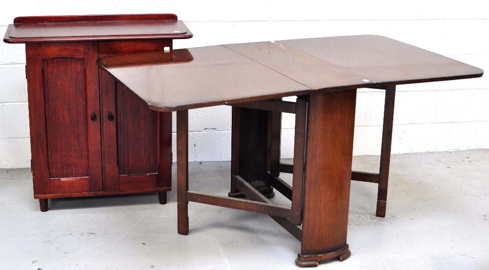 An early 20th century mahogany twin door cabinet with interior shelf on tapering feet,