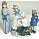 Three Nao figurines; a boy putting a bandage on a girl's foot,