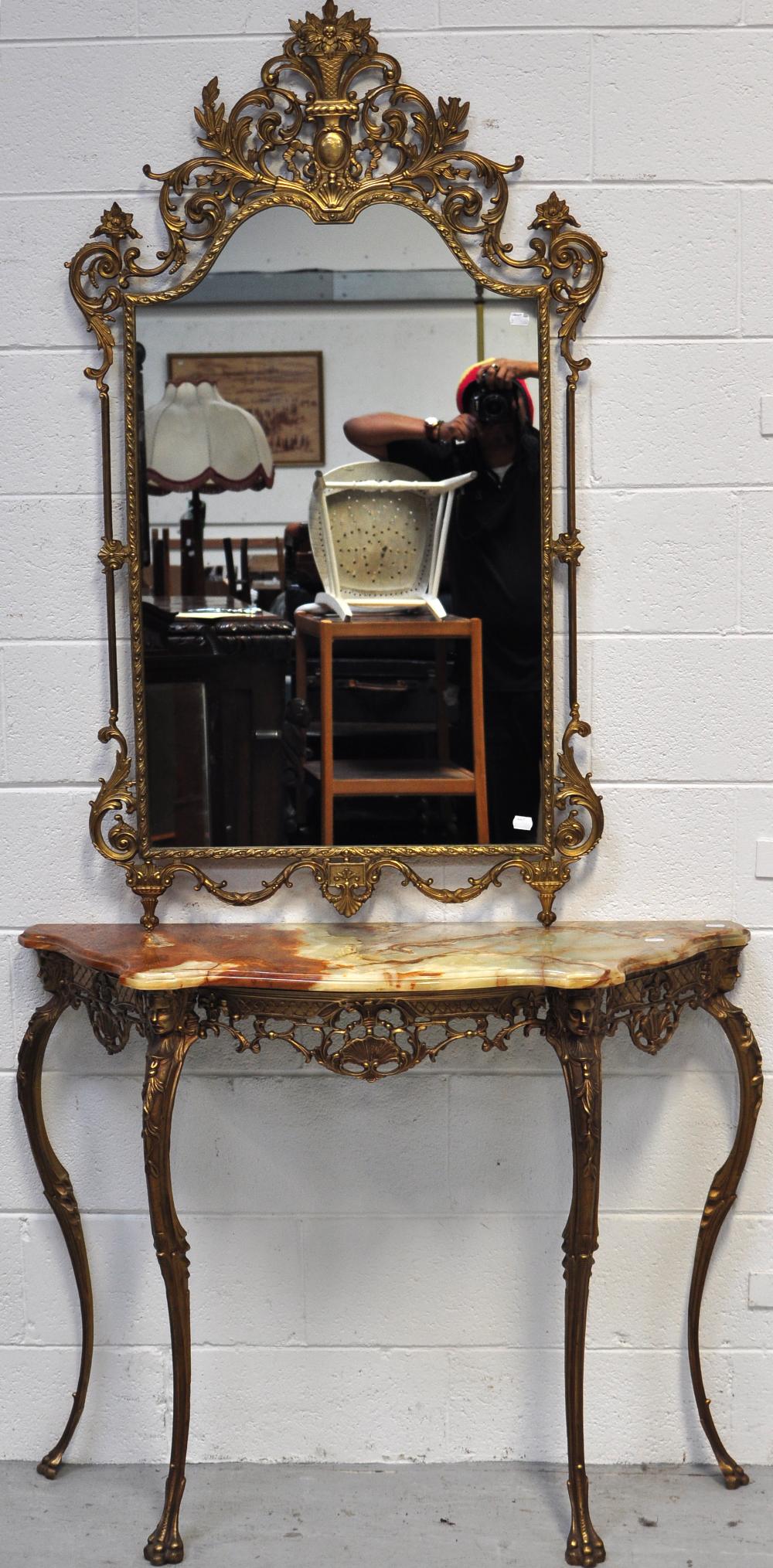 A metal gilded hall table with onyx top in the French style on cabriole legs with masque head