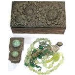 A metal jewellery box containing a white metal filigree bracelet set with carved green hardstone