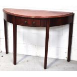 An early 20th century mahogany demi-lune table raised on fluted legs with central single drawer,