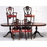 A reproduction mahogany extending dining table on two tripod supports with single extending leaf,