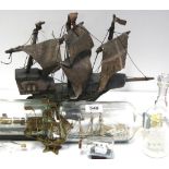 A model of a sailing ship and various ships in bottles.