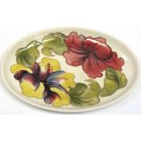 A Moorcroft Hibiscus dish on cream ground, impressed mark to base, diameter 24cm.