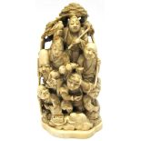 A Japanese Meiji period carved ivory okimono of figures hunting and in revelry, height 13cm.