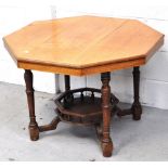 An early 20th century oak octagonal occasional table with lower shelf and raised on ring turned