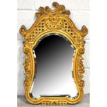 A Victorian gilded cast iron wall mirror with foliate C scroll pierced frame and central bevelled