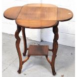 A 20th century oak drop leaf occasional table with lower shelf and raised on incised outswept